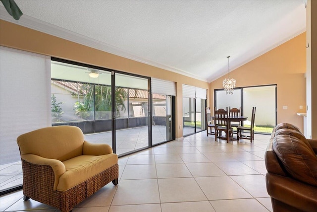 2646 Mohawk Cir, West Palm Beach, FL 33409 - living room featuring a chandelier, ornamental molding, lofted ceiling, and light tile patterned floors