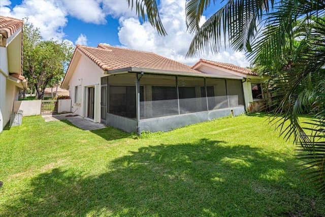 2646 Mohawk Cir, West Palm Beach, FL 33409 - rear view of property featuring a tiled roof, a sunroom, and stucco siding