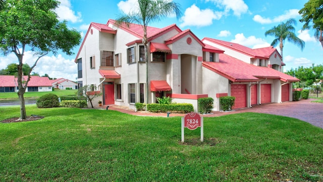 7824 Lexington Club Blvd Unit A, Delray Beach, FL 33446 - mediterranean / spanish house with a front lawn, stucco siding, asphalt driveway, and a tiled roof