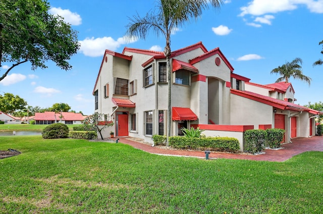 7824 Lexington Club Blvd Unit A, Delray Beach, FL 33446 - mediterranean / spanish house featuring a tiled roof, stucco siding, a front lawn, a garage, and a water view