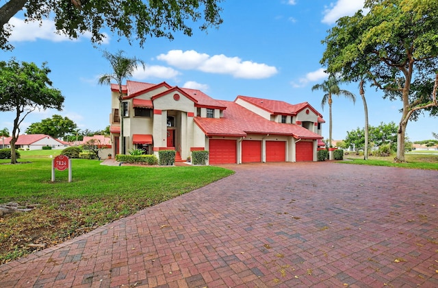 7824 Lexington Club Blvd Unit A, Delray Beach, FL 33446 - view of front of home with an attached garage, stucco siding, a front yard, a tile roof, and decorative driveway