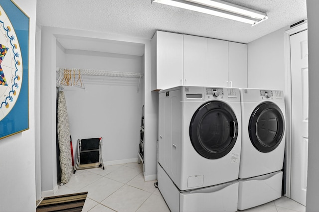 7824 Lexington Club Blvd Unit A, Delray Beach, FL 33446 - laundry room with washer and dryer, a textured ceiling, cabinet space, and light tile patterned flooring