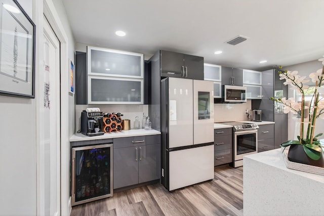 1170 S Drive Cir Unit B, Delray Beach, FL 33445 - kitchen with appliances with stainless steel finishes, beverage cooler, light wood-style flooring, light countertops, and gray cabinetry