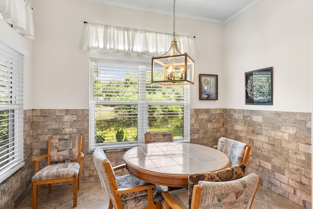 1200 SW Arrowhead Ct, Palm City, FL 34990 - dining area featuring tile walls, crown molding, a chandelier, wainscoting, and tile patterned flooring