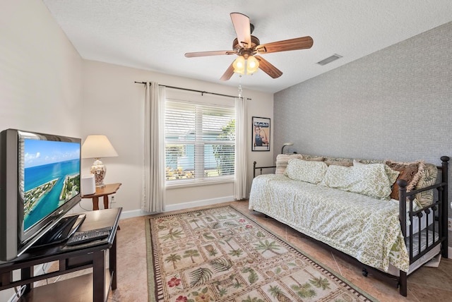 1200 SW Arrowhead Ct, Palm City, FL 34990 - bedroom featuring a textured ceiling, tile patterned floors, an accent wall, and a ceiling fan