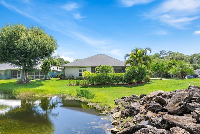 1200 SW Arrowhead Ct, Palm City, FL 34990 - rear view of house with a yard, a water view, and stucco siding