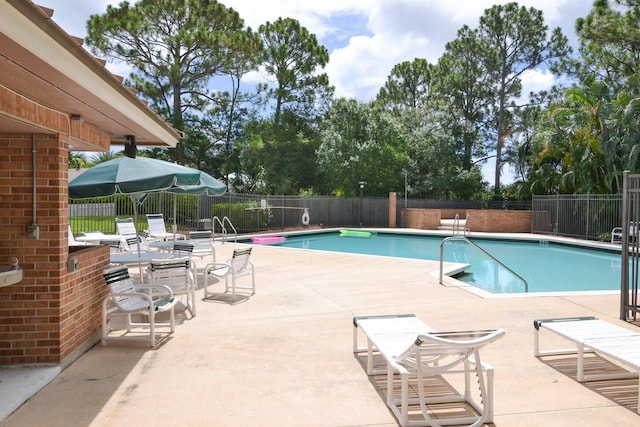 1200 SW Arrowhead Ct, Palm City, FL 34990 - community pool featuring a patio area and view of wooded area