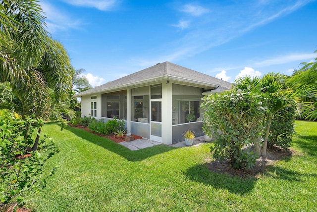 1200 SW Arrowhead Ct, Palm City, FL 34990 - back of property featuring a sunroom, stucco siding, a lawn, and a shingled roof
