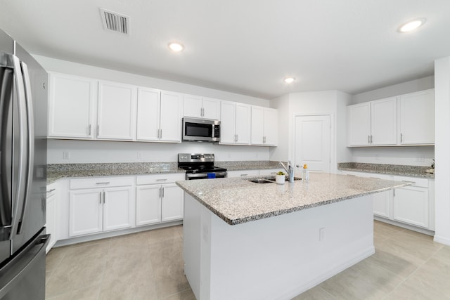 1312 SW Calmar Ave Unit 164, Port Saint Lucie, FL 34953 - kitchen with stainless steel appliances, white cabinetry, light stone counters, a kitchen island with sink, and recessed lighting