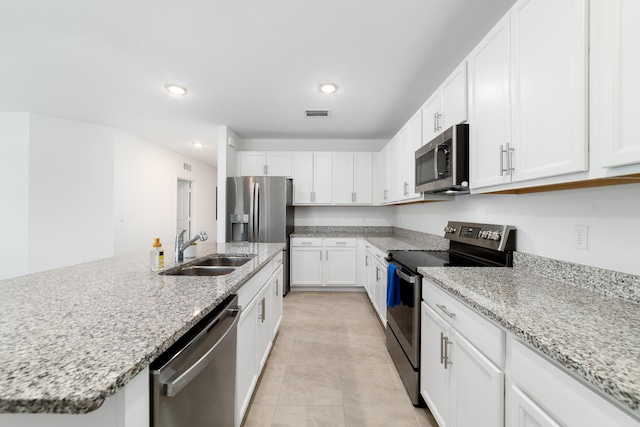 1312 SW Calmar Ave Unit 164, Port Saint Lucie, FL 34953 - kitchen featuring stainless steel appliances, white cabinetry, a center island with sink, recessed lighting, and light stone countertops