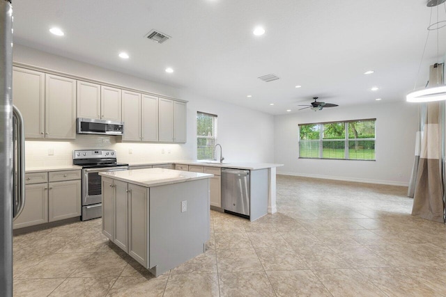 8183 Emerald Winds Cir, Boynton Beach, FL 33473 - kitchen with stainless steel appliances, gray cabinetry, a peninsula, healthy amount of natural light, and recessed lighting