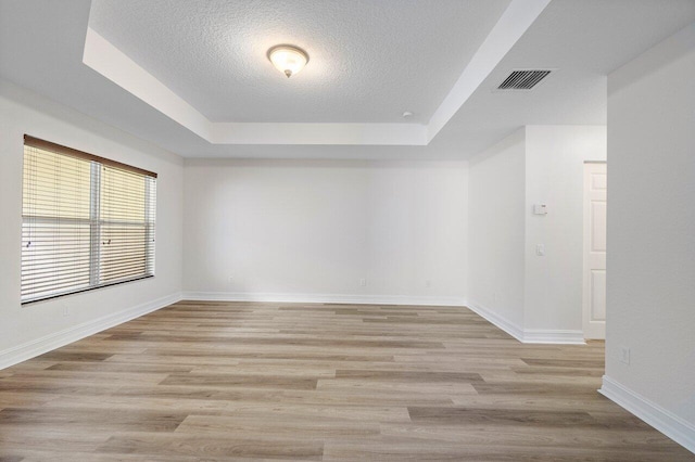 8183 Emerald Winds Cir, Boynton Beach, FL 33473 - spare room with a raised ceiling, a textured ceiling, and light wood-type flooring