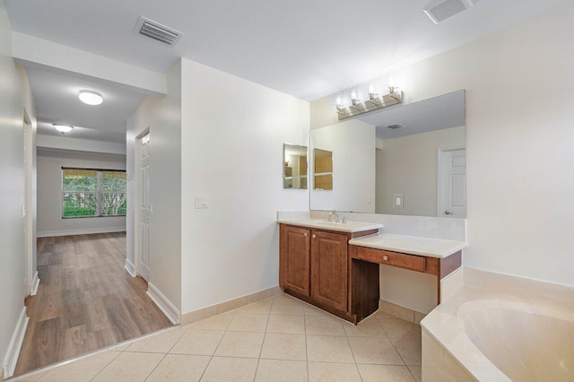8183 Emerald Winds Cir, Boynton Beach, FL 33473 - bathroom featuring a garden tub, vanity, and tile patterned flooring