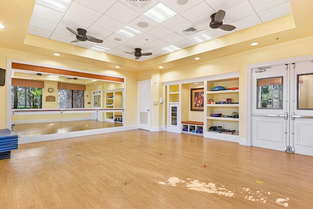 8183 Emerald Winds Cir, Boynton Beach, FL 33473 - workout room featuring a ceiling fan, a paneled ceiling, a raised ceiling, and wood finished floors