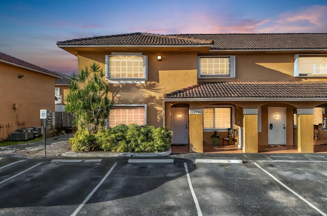 7853 W 36th Ave Unit 104, Hialeah, FL 33018 - view of front of home featuring a tiled roof, uncovered parking, stucco siding, and a porch