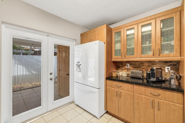 7853 W 36th Ave Unit 104, Hialeah, FL 33018 - kitchen featuring white fridge with ice dispenser, tasteful backsplash, light tile patterned flooring, glass insert cabinets, and dark stone countertops