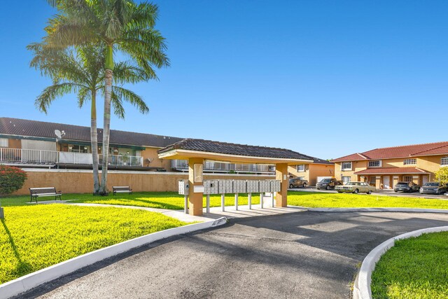 7853 W 36th Ave Unit 104, Hialeah, FL 33018 - view of front of house with a residential view, stucco siding, and a front lawn