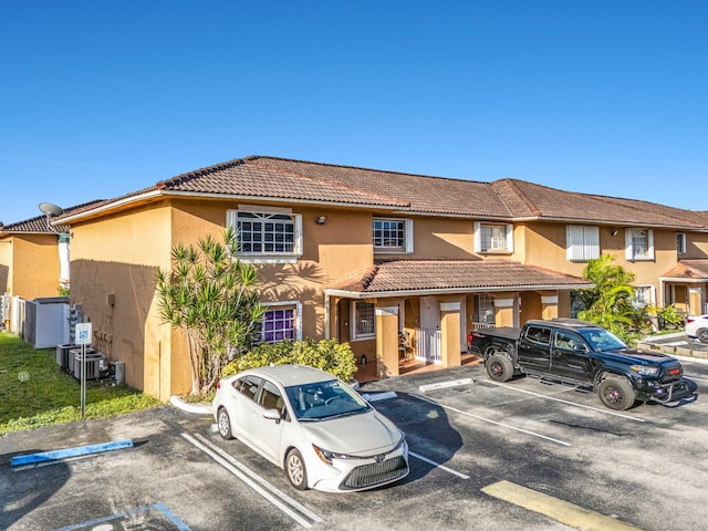 7853 W 36th Ave Unit 104, Hialeah, FL 33018 - townhome / multi-family property featuring a tile roof, uncovered parking, and stucco siding