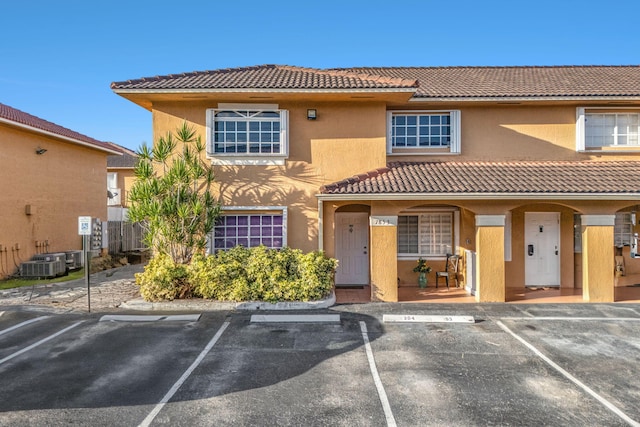 7853 W 36th Ave Unit 104, Hialeah, FL 33018 - view of front facade featuring a tile roof, uncovered parking, and stucco siding