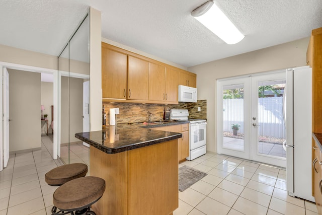 7853 W 36th Ave Unit 104, Hialeah, FL 33018 - kitchen featuring white appliances, a textured ceiling, a peninsula, decorative backsplash, and french doors
