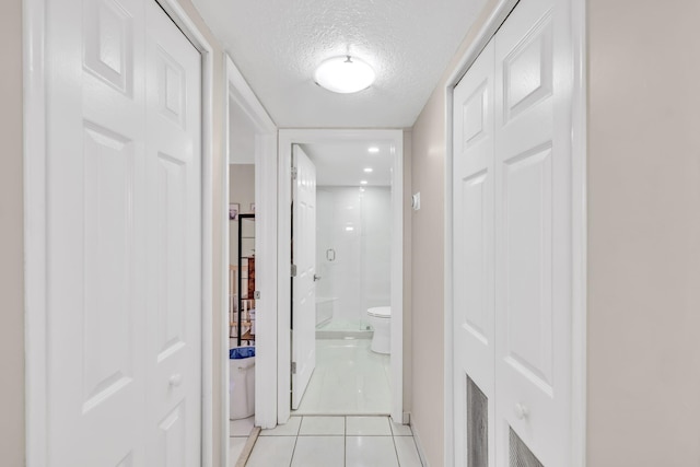 7853 W 36th Ave Unit 104, Hialeah, FL 33018 - hallway with light tile patterned flooring and a textured ceiling