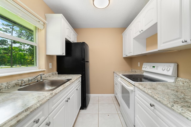 16888 W Stallion Dr, Loxahatchee, FL 33470 - kitchen with white electric range, white cabinets, light tile patterned floors, freestanding refrigerator, and a textured ceiling