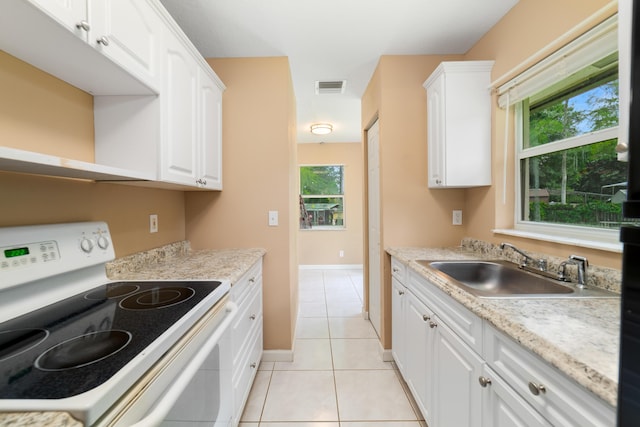 16888 W Stallion Dr, Loxahatchee, FL 33470 - kitchen with white range with electric stovetop, white cabinets, light tile patterned floors, and light countertops