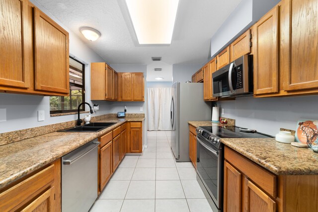 16888 W Stallion Dr, Loxahatchee, FL 33470 - kitchen featuring appliances with stainless steel finishes, light tile patterned flooring, and brown cabinetry