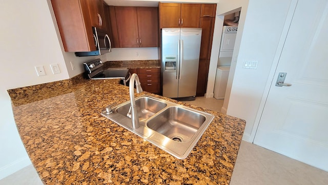 450 N Federal Hwy Unit 1101, Boynton Beach, FL 33435 - kitchen featuring appliances with stainless steel finishes, stacked washing machine and dryer, brown cabinetry, a peninsula, and light tile patterned floors