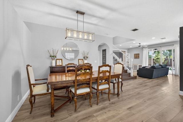 9196 Dupont Pl, Wellington, FL 33414 - dining room with light wood finished floors, arched walkways, stairs, recessed lighting, and a chandelier