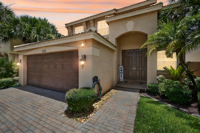 9196 Dupont Pl, Wellington, FL 33414 - view of front of home with stucco siding, an attached garage, and driveway