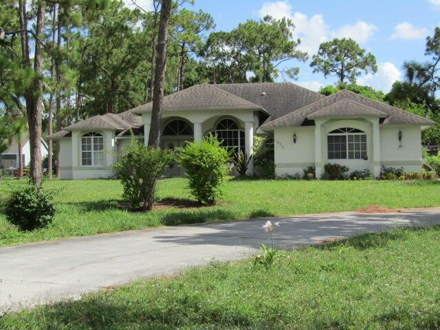 14575 Orange Blvd, Loxahatchee, FL 33470 - ranch-style house with a front lawn and stucco siding