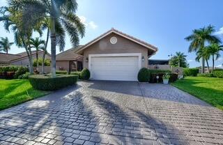 19261 Cherry Hills Ter, Boca Raton, FL 33498 - ranch-style house with decorative driveway, an attached garage, and a front yard