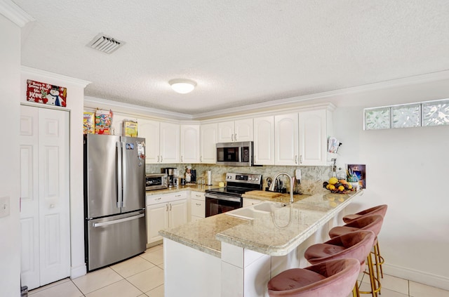 3385 Seabreeze Ln, Margate, FL 33063 - kitchen featuring stainless steel appliances, a peninsula, light tile patterned flooring, crown molding, and a breakfast bar
