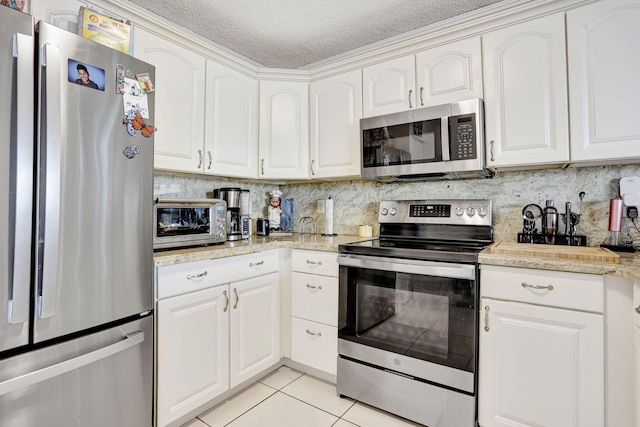 3385 Seabreeze Ln, Margate, FL 33063 - kitchen with appliances with stainless steel finishes, a textured ceiling, backsplash, light tile patterned floors, and light countertops