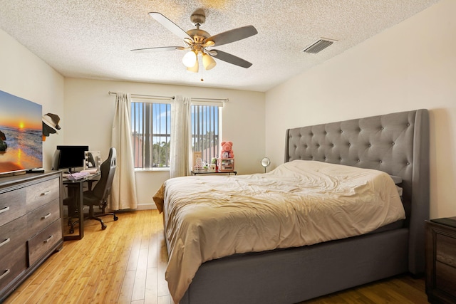 3385 Seabreeze Ln, Margate, FL 33063 - bedroom with light wood finished floors, an office area, a textured ceiling, and a ceiling fan