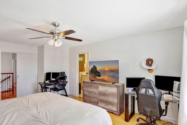 3385 Seabreeze Ln, Margate, FL 33063 - bedroom featuring an office area, light wood finished floors, a textured ceiling, and ceiling fan