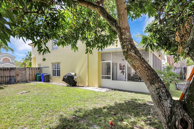3385 Seabreeze Ln, Margate, FL 33063 - rear view of house with a fenced backyard, a sunroom, stucco siding, and a gate