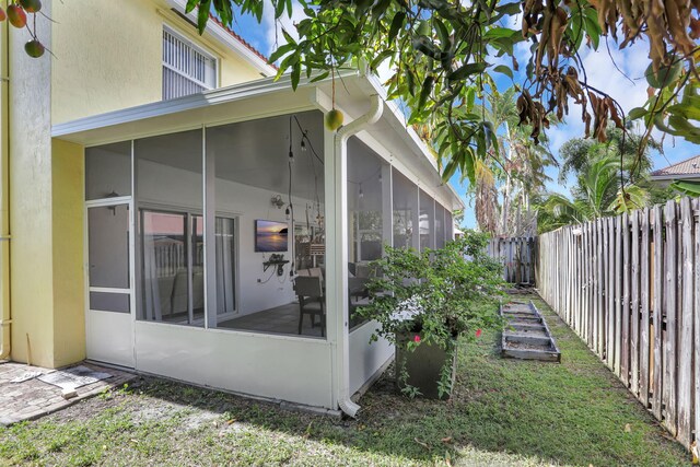 3385 Seabreeze Ln, Margate, FL 33063 - view of home's exterior featuring a sunroom, a fenced backyard, and stucco siding