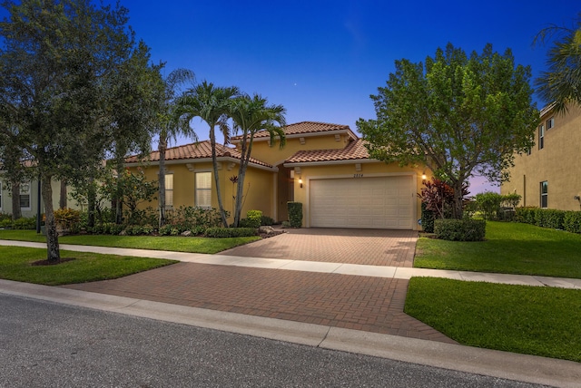 2854 Bellarosa Cir, Royal Palm Beach, FL 33411 - mediterranean / spanish house with decorative driveway, an attached garage, a tiled roof, stucco siding, and a front lawn