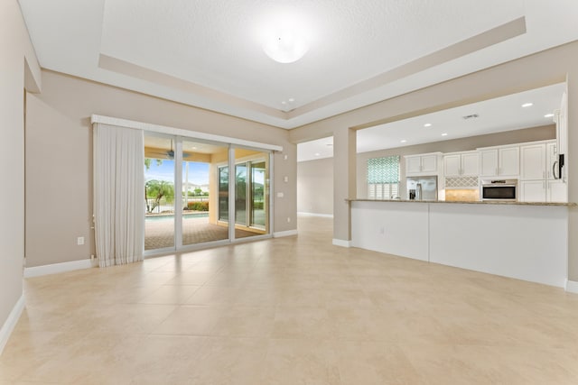2854 Bellarosa Cir, Royal Palm Beach, FL 33411 - unfurnished living room with a raised ceiling, recessed lighting, and light tile patterned floors