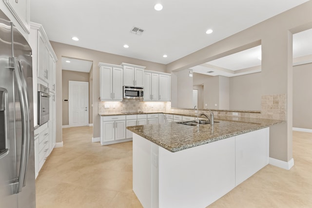 2854 Bellarosa Cir, Royal Palm Beach, FL 33411 - kitchen with appliances with stainless steel finishes, backsplash, a peninsula, light stone counters, and white cabinetry