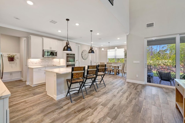 4610 SW Ardsley Dr, Stuart, FL 34997 - kitchen featuring stainless steel appliances, light countertops, light wood-style floors, recessed lighting, and crown molding