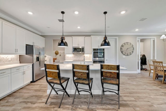 4610 SW Ardsley Dr, Stuart, FL 34997 - kitchen featuring stainless steel appliances, ornamental molding, tasteful backsplash, light countertops, and white cabinetry