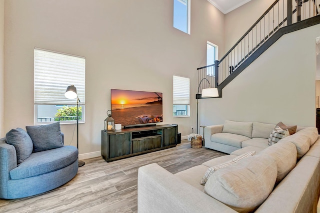 4610 SW Ardsley Dr, Stuart, FL 34997 - living area with ornamental molding, a towering ceiling, wood finished floors, and stairway