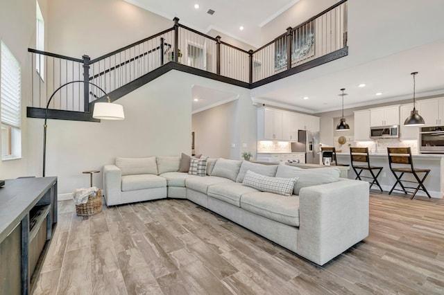 4610 SW Ardsley Dr, Stuart, FL 34997 - living room featuring ornamental molding, a high ceiling, recessed lighting, and light wood-type flooring