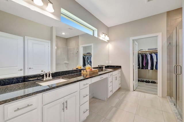4610 SW Ardsley Dr, Stuart, FL 34997 - full bathroom with a walk in closet, double vanity, a shower stall, and tile patterned floors