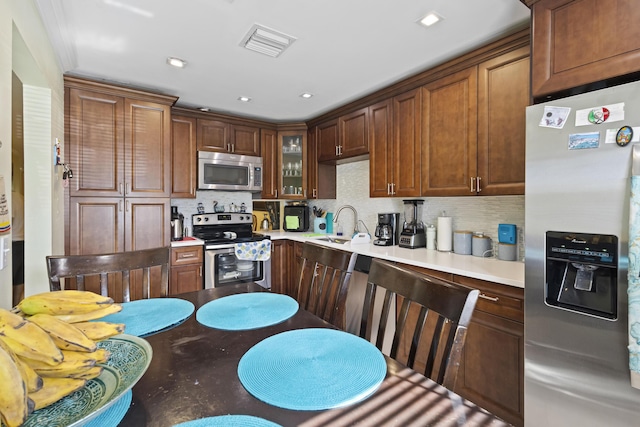 5800 Fernley Dr W Unit 54, West Palm Beach, FL 33415 - kitchen featuring appliances with stainless steel finishes, backsplash, glass insert cabinets, light countertops, and recessed lighting