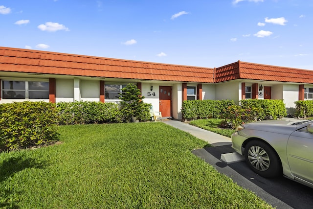 5800 Fernley Dr W Unit 54, West Palm Beach, FL 33415 - view of property with a front yard, a tile roof, stucco siding, and mansard roof