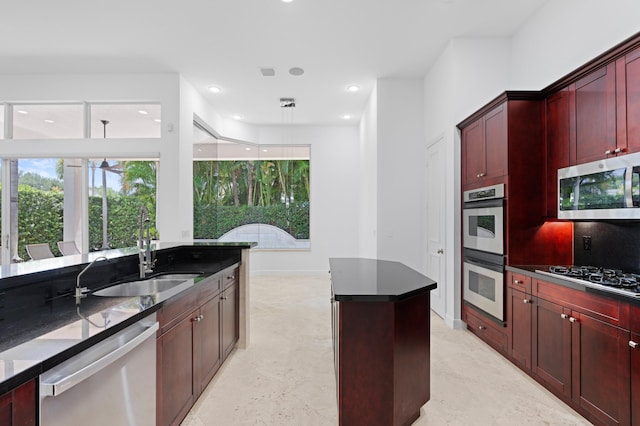 16284 Via Venetia W, Delray Beach, FL 33484 - kitchen with stainless steel appliances, reddish brown cabinets, a center island, recessed lighting, and decorative light fixtures
